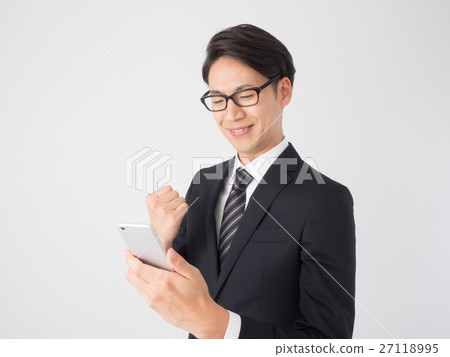 A businessman looking at a smartphone and doing a guts pose 27118995