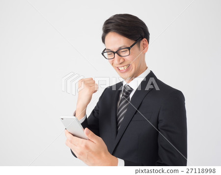 A businessman looking at a smartphone and doing a guts pose 27118998