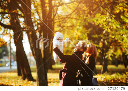 young family and newborn son in autumn park young family and newborn son in autumn park 27120479