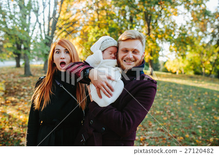 young family and newborn son in autumn park young family and newborn son in autumn park 27120482