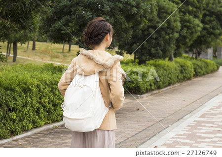 A woman carrying a backpack A woman carrying a backpack 27126749