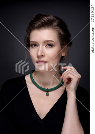 Portrait of a young girl with expressive eyes on a dark backgrou 27129124
