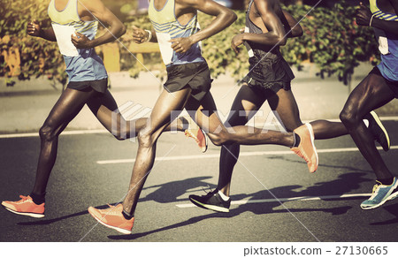 marathon runners running on city road 27130665