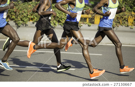 marathon runners running on city road 27130667