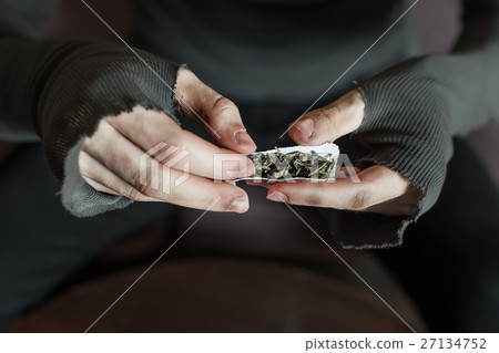 Addict hands making marijuana jamb closeup. 27134752