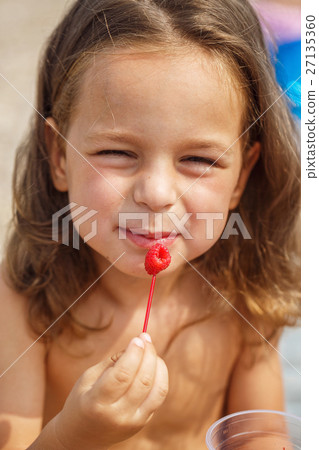 Beautiful boy is eating raspberries Beautiful boy is eating raspberries 27135360