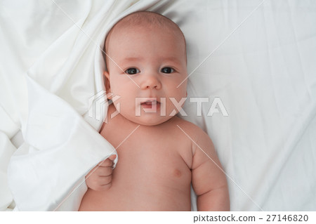 Baby boy lying on white linen close up studio shot Baby boy lying on white linen close up studio shot 27146820