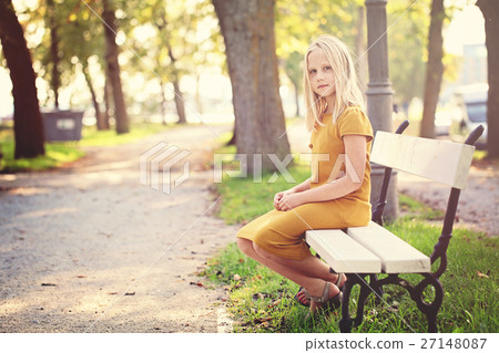 Young Girl Sitting on a Bench 27148087