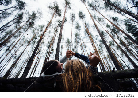 Loving couple lying on the flooring in the forest 27152032
