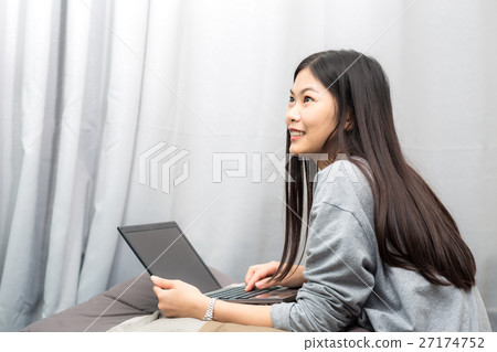 Happy teenage girl using modern laptop on bed Happy teenage girl using modern laptop on bed 27174752