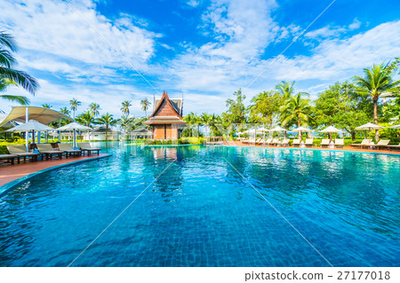 Umbrella and chair around swimming pool 27177018