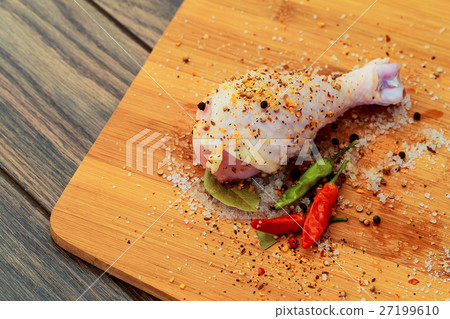 Raw chicken drumsticks on cutting board. Raw chicken drumsticks on cutting board. 27199610