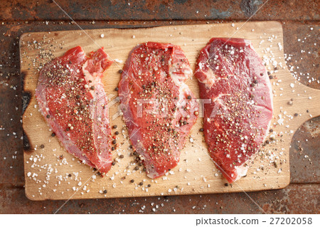 Raw beef steak and spicel on cutting board 27202058