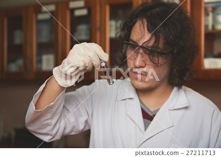 Chemist with colour liqiud in flask 27211713