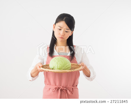A woman looking cabbage anxiously 27211845