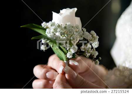 Close-up of a bride holding a boutonniere. 27215524