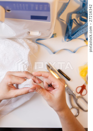 Seamstress in atelier unrips fabric Seamstress in atelier unrips fabric 27216342