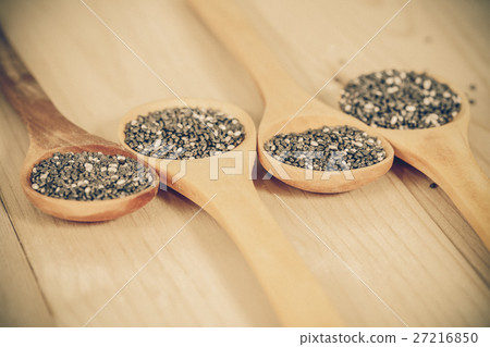 Nutritious chia seeds on a wooden spoon Nutritious chia seeds on a wooden spoon 27216850