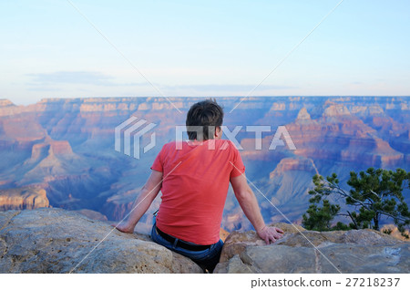 Man sitting on stone and looking of the Grand Canyon Man sitting on stone and looking of the Grand Canyon 27218237