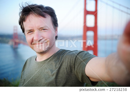 Middle age man making a self portrait with Golden Gate bridge in 27218238