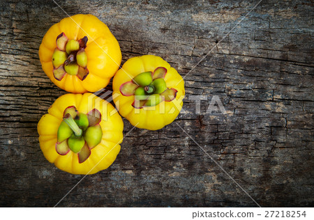 Garcinia cambogia fresh fruit on wood background. Garcinia cambogia fresh fruit on wood background. 27218254