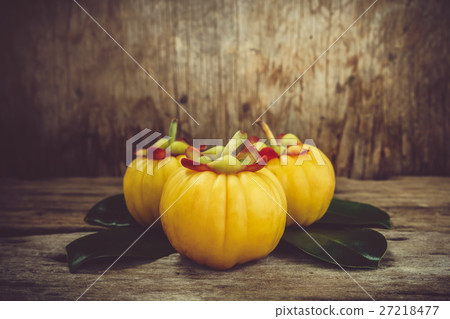 Garcinia cambogia fruit on wood background. Garcinia cambogia fruit on wood background. 27218477