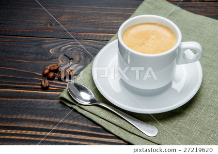 roasted coffee beans and cup on wooden background 27219620
