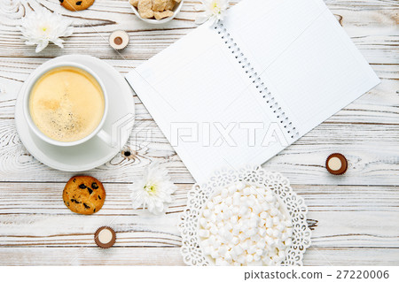 cup of coffee and note pad on light wooden table cup of coffee and note pad on light wooden table 27220006