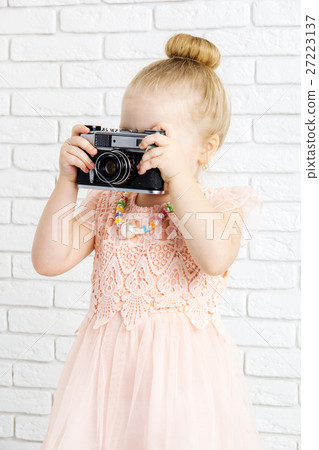 Little girl with retro camera in hand Little girl with retro camera in hand 27223137