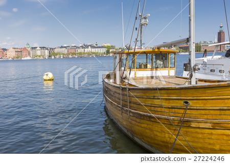 Old city buildings and old boats on water 27224246
