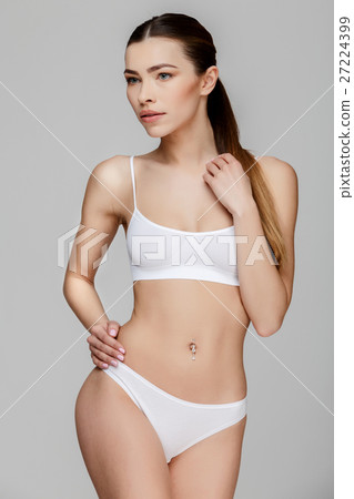Slim tanned woman's body over gray background 27224399