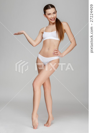 Slim tanned woman's body over gray background 27224409