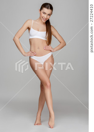 Slim tanned woman's body over gray background 27224410