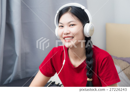 Young Asian woman red shirt listening to music Young Asian woman red shirt listening to music 27226243