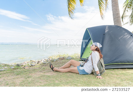 Hipster traveler woman relax with tent on dam location Hipster traveler woman relax with tent on dam location 27233527
