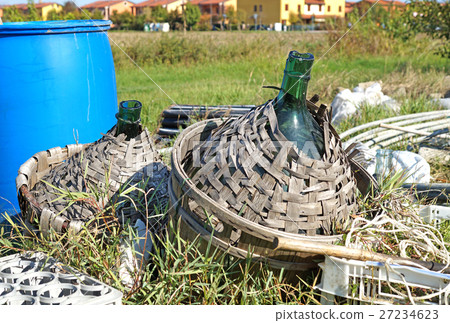 Old demijohn glass wrapped in wicker. Old demijohn glass wrapped in wicker. 27234623