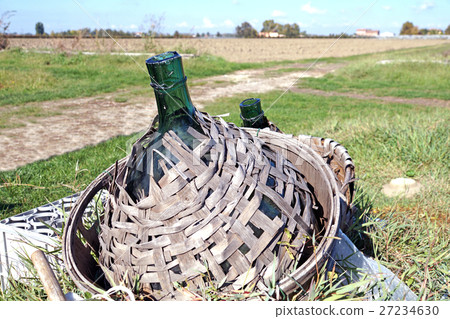 Old demijohn glass wrapped in wicker. Old demijohn glass wrapped in wicker. 27234630