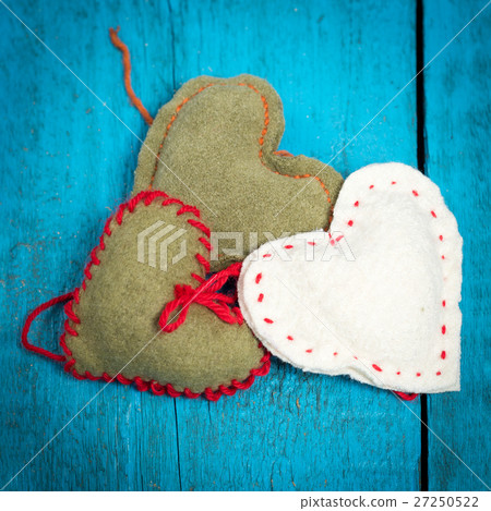 Colorful knitted hearts on the blue boards 27250522