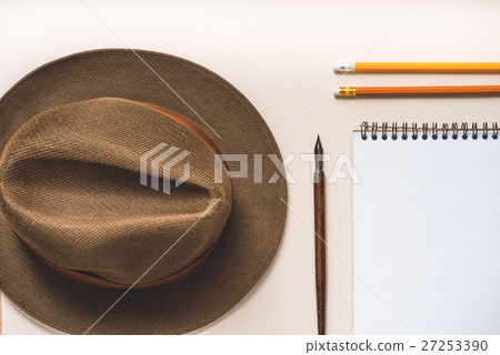 Brown hat near writing materials Brown hat near writing materials 27253390