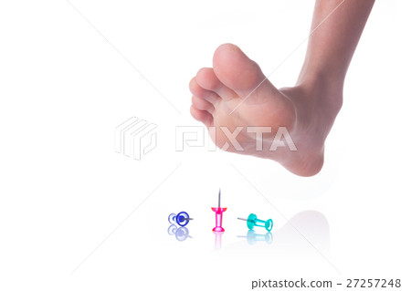 Foot about to step on sharp push pins 27257248
