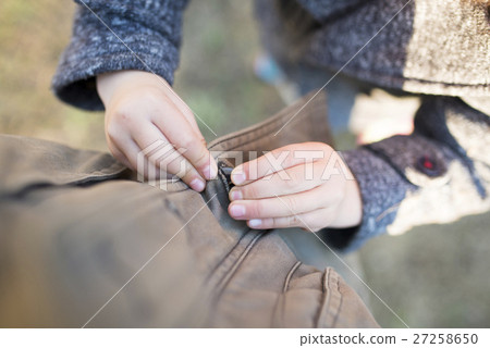 孩子的手夾著外套鈕扣 孩子的手夾著外套鈕扣 27258650