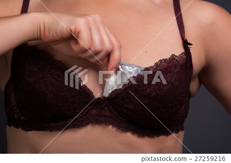 Woman in sexy lingerie holding condom Woman in sexy lingerie holding condom 27259216