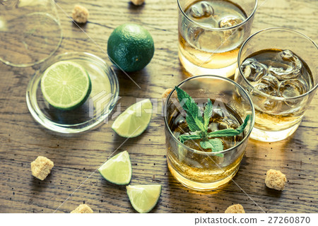 Glass of rum on the wooden background Glass of rum on the wooden background 27260870