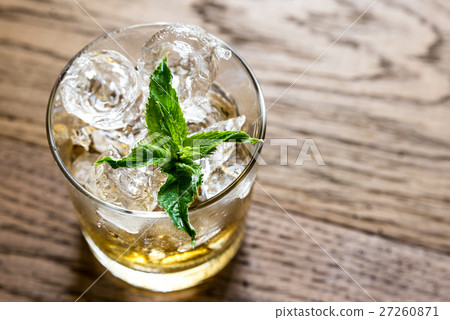 Glass of rum on the wooden background Glass of rum on the wooden background 27260871