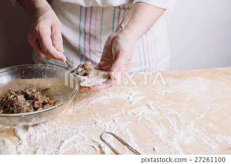 Two hands making meat dumplings. 27261100
