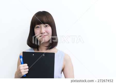 Smiling young lady holding a binder in front of the white board Smiling young lady holding a binder in front of the white board 27267452
