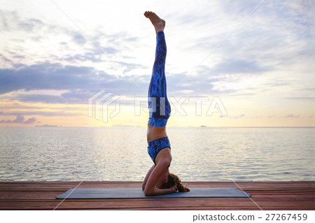Young woman practicing yoga on the sunset beach 27267459