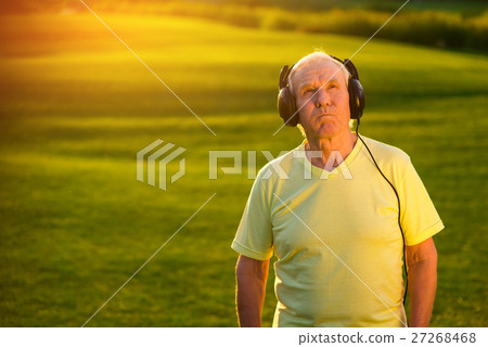 Elderly man in headphones. 27268468