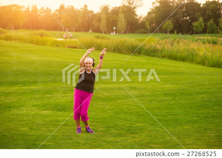 Lady in headphones dancing. 27268525