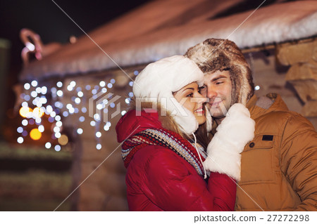 Happy couple outdoor in evening Christmas lights Happy couple outdoor in evening Christmas lights 27272298